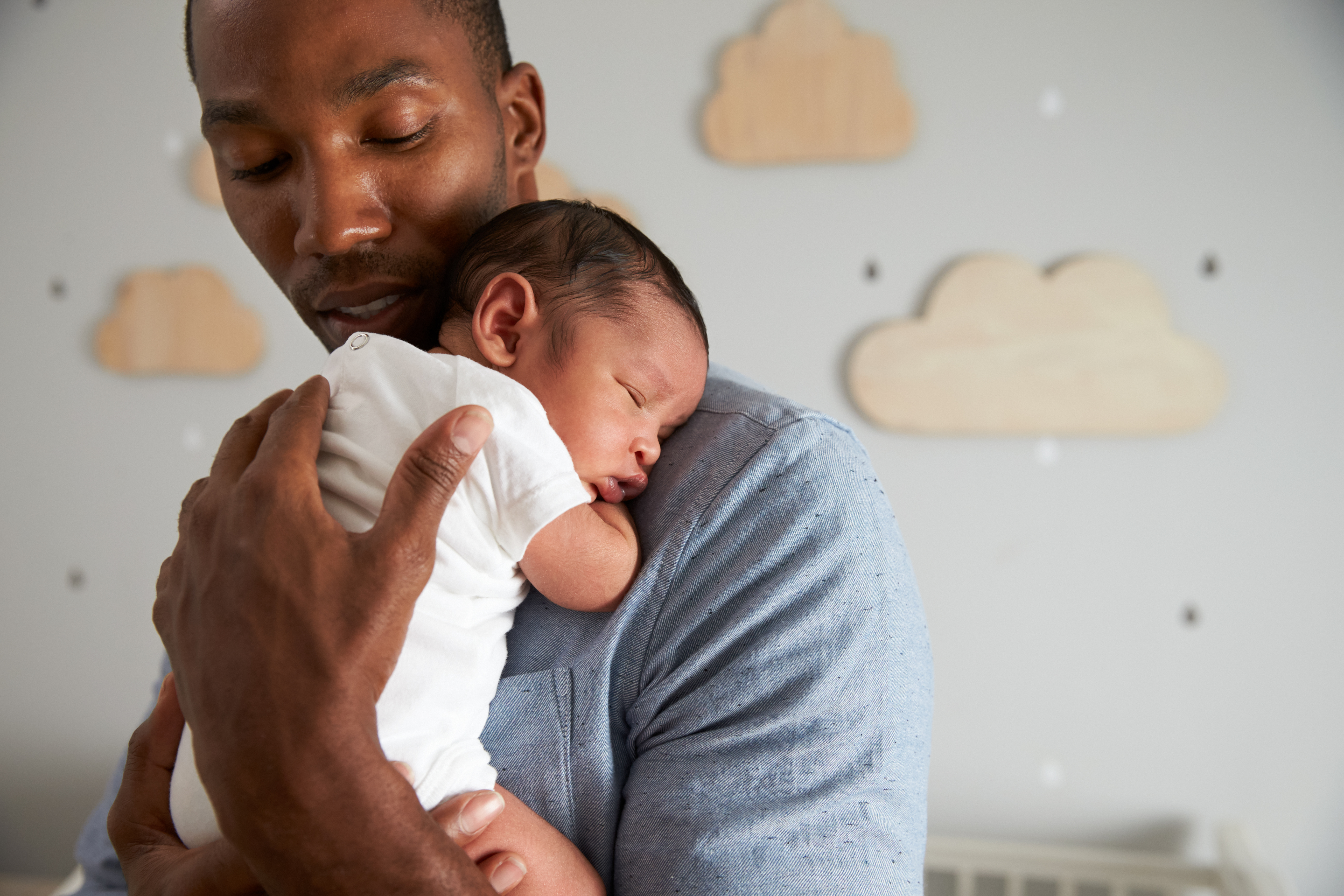 A man holds a sleeping baby